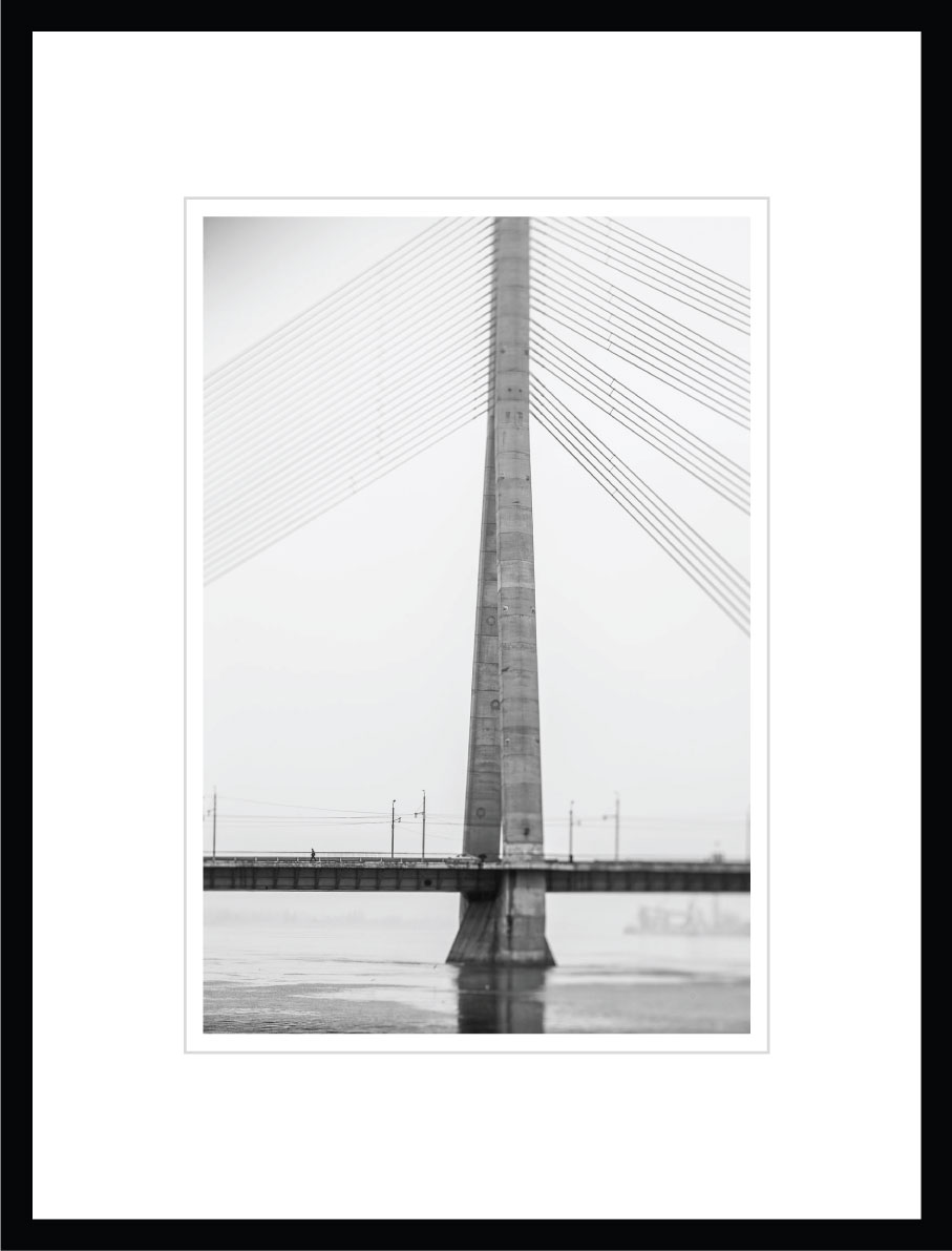 A man walks on a cable-stayed bridge.